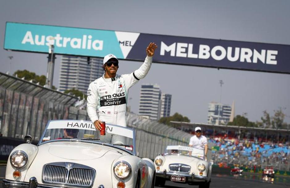 Tra una coca cola e un saluto alla folla, Lewis Hamilton si prepara alla gara. Epa